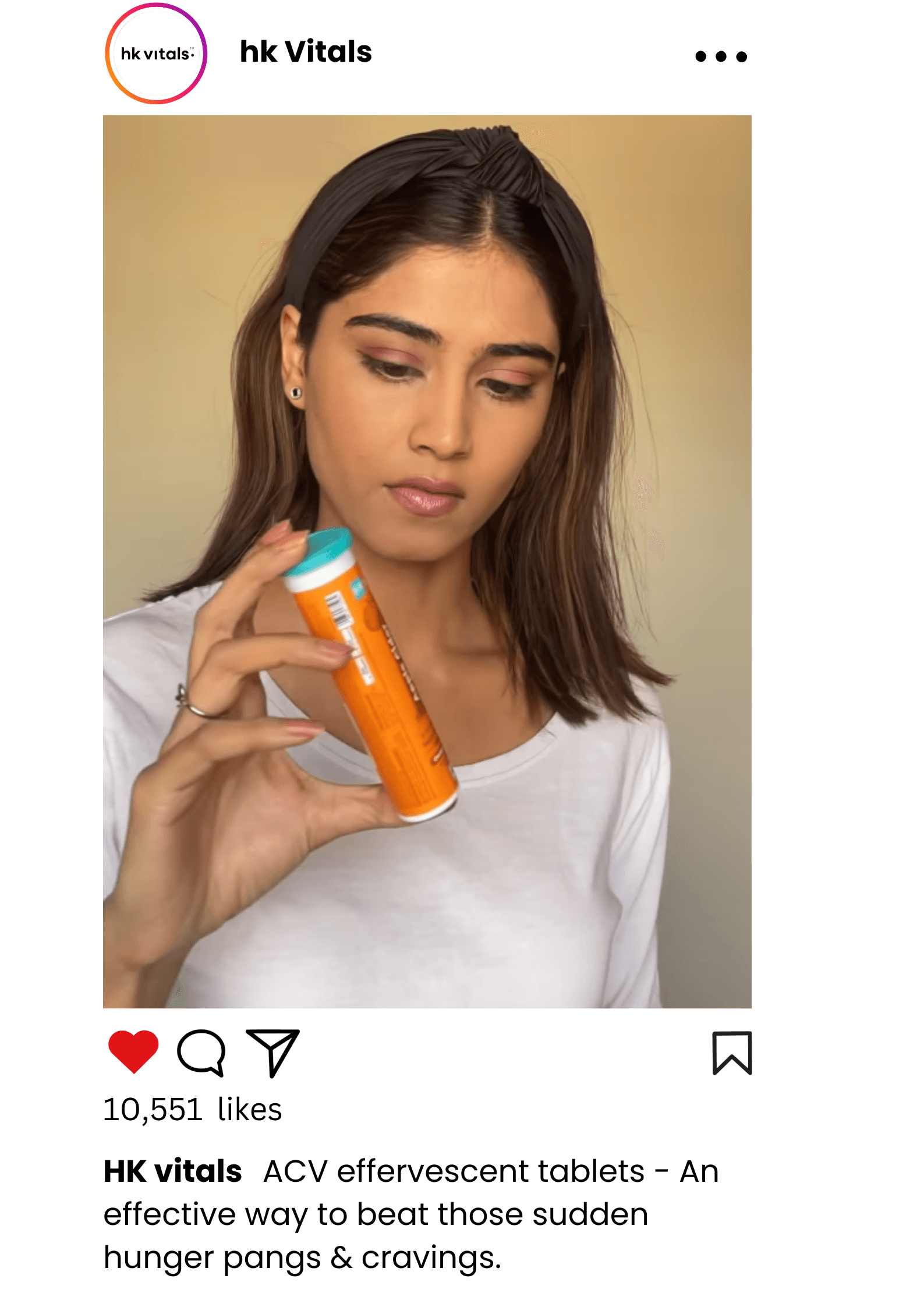 Person holding an orange HK Vitals product, likely during a video shoot for marketing purposes.