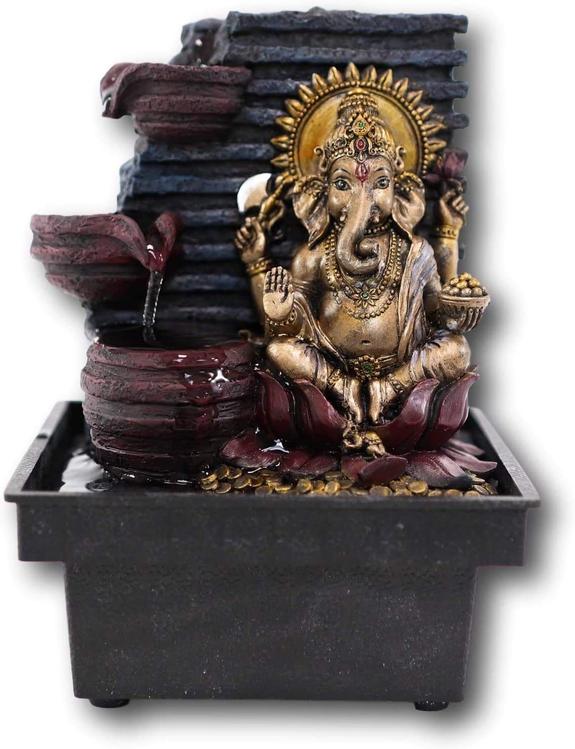 Ganesha statue in a decorative water fountain with tiered bowls, showcasing cultural significance and intricate design.